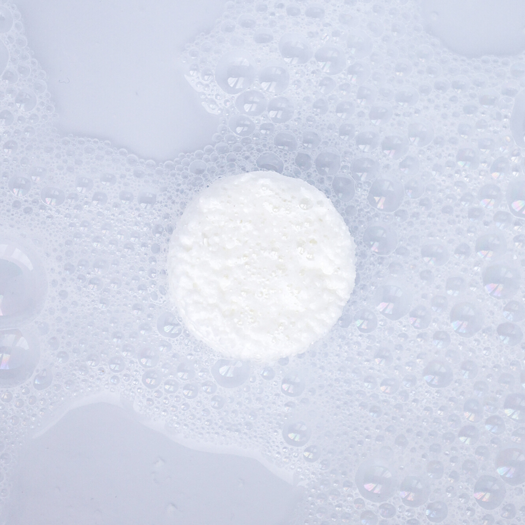 shower fizzes bomb sitting on the shower floor submerged in water fizzing and bubbling