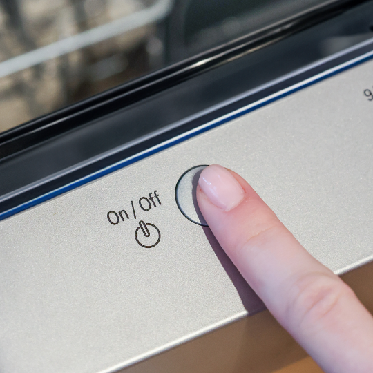 How to use dishwasher tablets 3: finger is pressing the on button on the dishwasher to run a normal cycle 