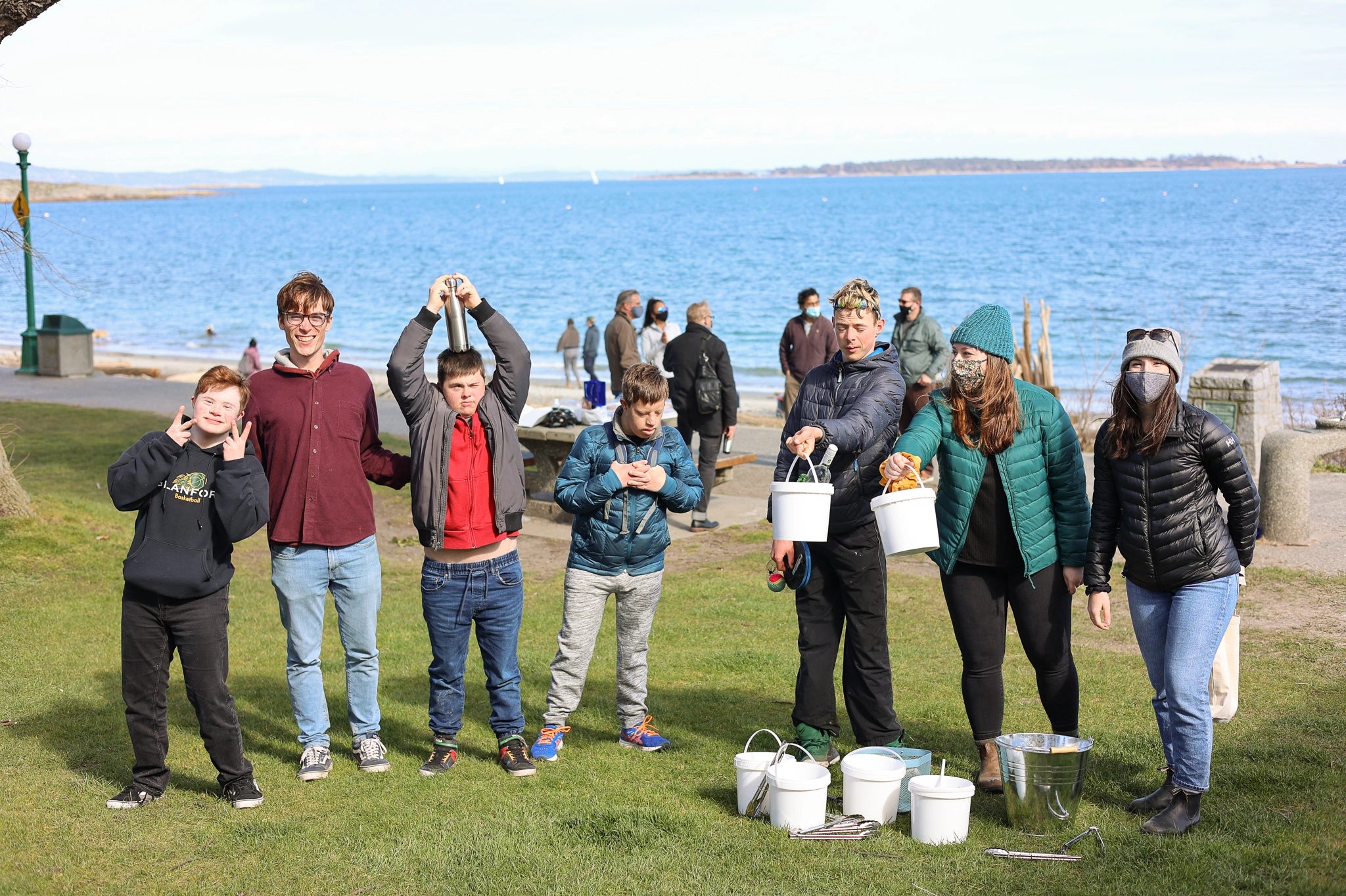 Nature Bee partners with local organizations to give back through community events and donations. Picture includes the nature bee team and members of the community outdoors doing a beach clean up. 