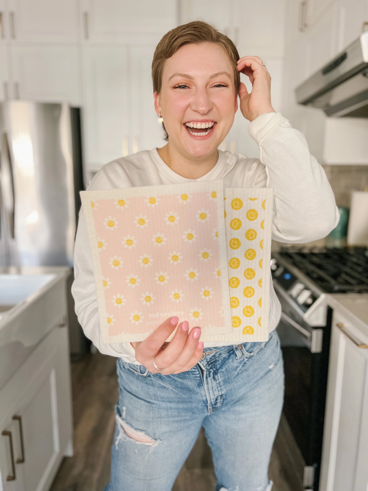 Breanne Allarie in a kitchen holding her set of limited edition swedish dishcloths made with Nature Bee. Proceeds donated to balding for dollars. 